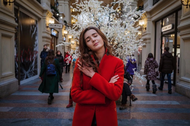 MOSCA MARZO 2017 ritratto di giovane donna all'interno dei grandi magazzini Gum a Mosca una donna con un bel cappotto rosso cammina per i grandi magazzini GUM in cerca di regali