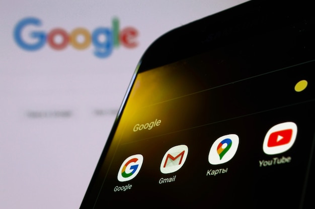Mosca, Russia - 22 ottobre 2021: Smartphone con applicazioni google sullo sfondo di un sito google aperto nel browser.