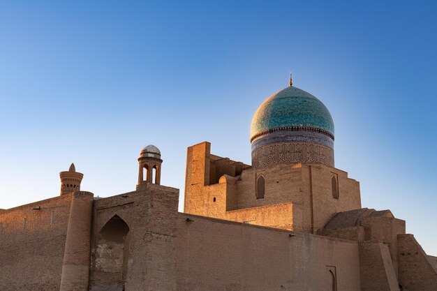 Moschea di Kalyan con antiche mura e una grande cupola colorata contro il chiaro cielo dell'alba Bukhara Uzbekistan