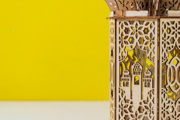 moschea in miniatura in legno con sfondo giallo Eid Mubarak