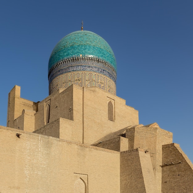 Moschea Kalyan con antiche mura e grande cupola colorata contro il cielo blu chiaro Bukhara Uzbekistan