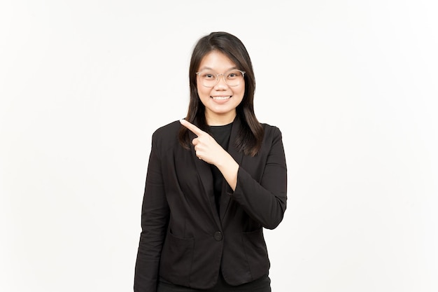 Mostrando il prodotto e indicando il lato della bella donna asiatica che indossa un blazer nero isolato su bianco