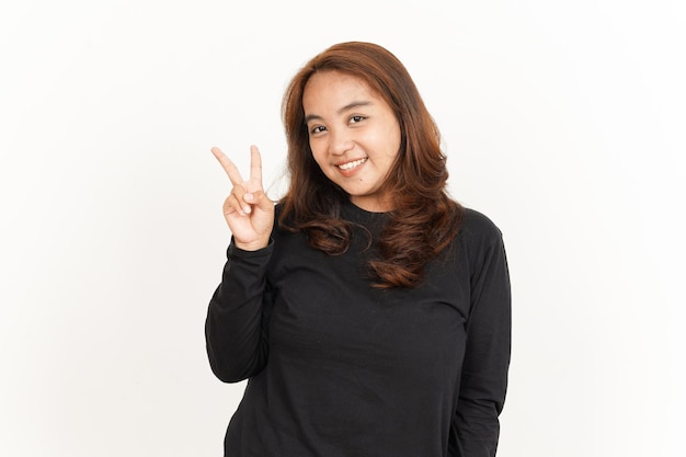 Mostrando il segno di pace della bella donna asiatica che indossa una camicia nera isolata su sfondo bianco