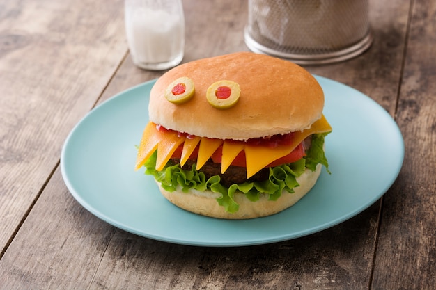 Mostro di hamburger di Halloween sulla tavola di legno