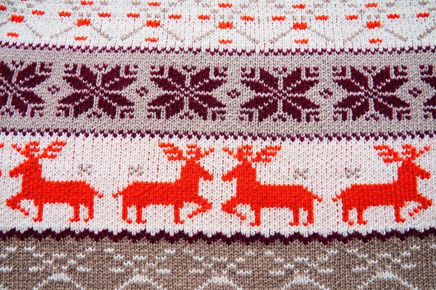 Motivo a maglia jacquard Ornamento geometrico per Natale o Capodanno Quattro cervi rossi su uno sfondo bianco lavorato a maglia strisce di fiocchi di neve Ornamento popolare tradizionale animale moderno alla moda invernale