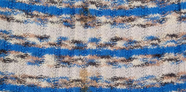Motivo a maglia. Primo piano di tessitura di lana lavorata a maglia. Modello multicolore lavorato a maglia come sfondo.
