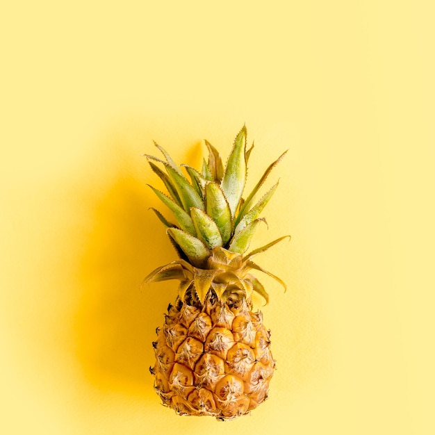 Motivo di sfondo astratto tropicale con cocco e ananas su sfondo giallo concetto estivo