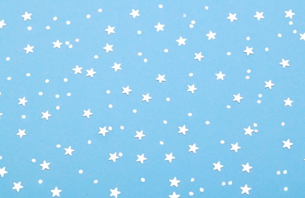 Motivo natalizio fatto di stelle d'argento su sfondo blu Concetto invernale Posa piatta