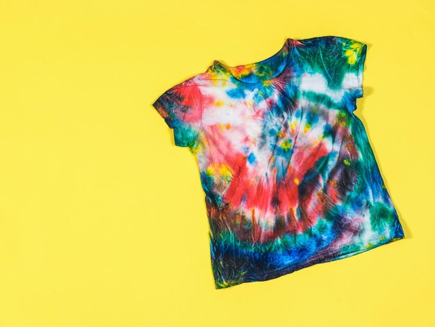 Motivo tie dye su una maglietta su sfondo giallo Piatto