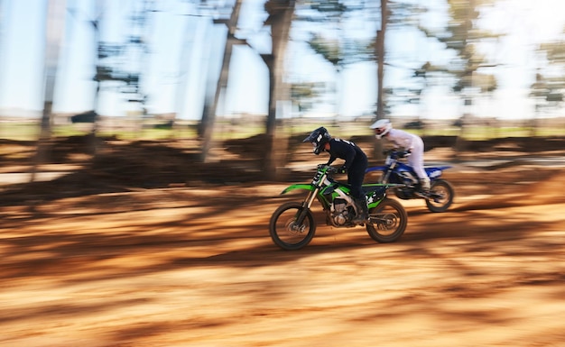 Moto da corsa e uomini sportivi con velocità per la pratica e l'allenamento in avventure veloci Sfocatura di movimento professionale in mountain bike e gare di moto fuoristrada e sfide nei boschi