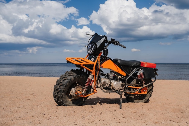 Motocicletta sportiva fuoristrada personalizzata parcheggiata sulla spiaggia all'aperto