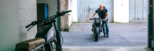 Motociclista che porta la moto al garage