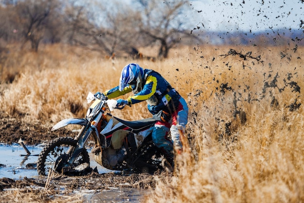 Motociclista enduro bloccato nel fango profondo