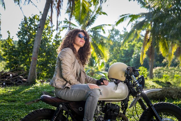 Motociclista femmina alla guida di una moto cafe racer