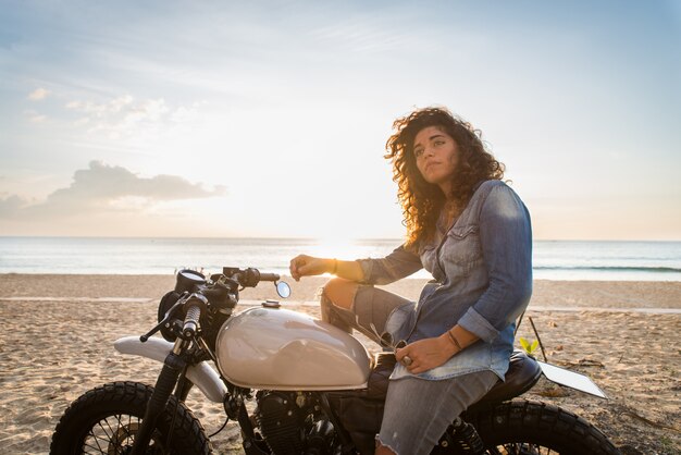 Motociclista femmina alla guida di una moto cafe racer