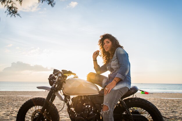 Motociclista femmina alla guida di una moto cafe racer