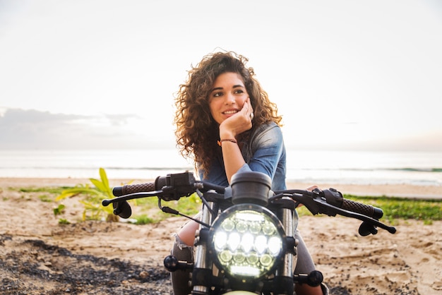 Motociclista femmina alla guida di una moto cafe racer