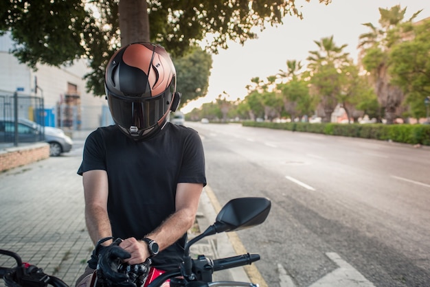 Motociclista in città. Indossare i guanti per mettersi in viaggio.