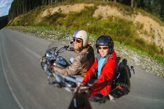 Motociclista in sella alla sua moto sulla strada con il passeggero