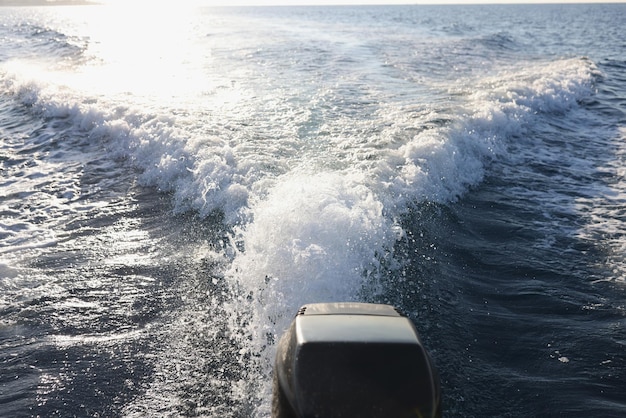 Motore per yacht e lunga scia d'acqua con spruzzi e schiuma dietro le avventure in mare del turismo marino