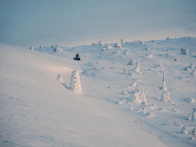 Motoslitta sul nevaio Sport invernali Montagne innevate e tempo nuvoloso con bufera di neve nelle montagne Khibiny Russia