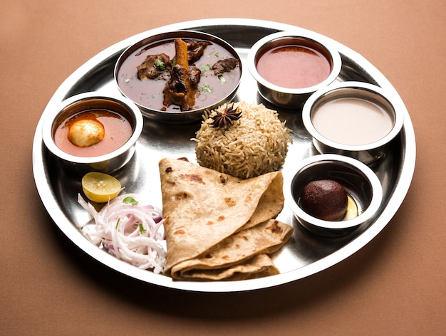 Motton Thali O Gosht, il piatto di agnello è un menu per pranzo o cena indiano asiatico non vegetariano composto da carne, curry di uova con chapati, riso, insalata e dolce Gulab Jamun