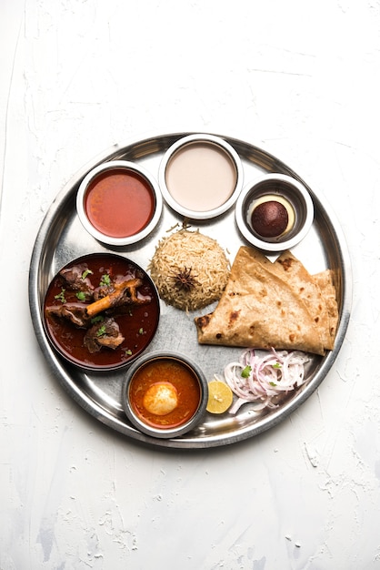 Motton Thali O Gosht, il piatto di agnello è un menu per pranzo o cena indiano asiatico non vegetariano composto da carne, curry di uova con chapati, riso, insalata e dolce Gulab Jamun