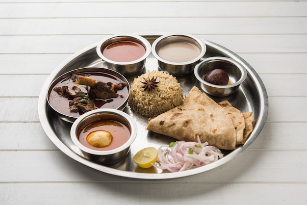 Motton Thali O Gosht, il piatto di agnello è un menu per pranzo o cena indiano asiatico non vegetariano composto da carne, curry di uova con chapati, riso, insalata e dolce Gulab Jamun