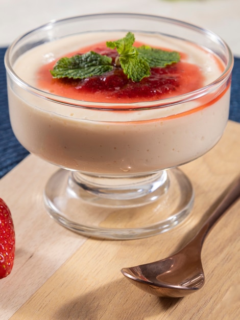 Mousse al limone in coppa di cristallo con topping di gelatina di fragole e menta.