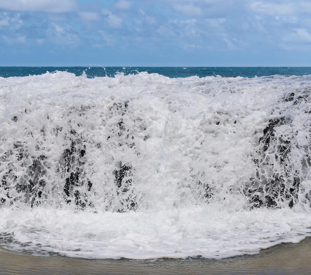 Movimento congelato della cascata dell'oceano sulle rocce a Lumahai Beach