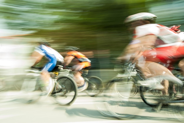 Movimento sfocato di uno sportivo in bicicletta per strada durante la gara