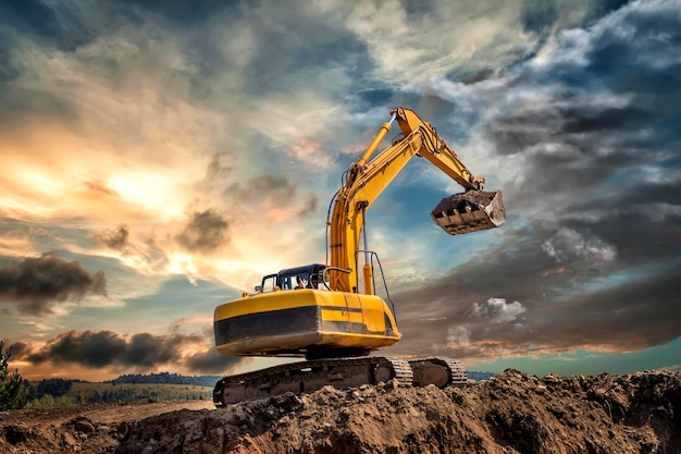 Movitore di terra sul cantiere contro il cielo durante il tramonto