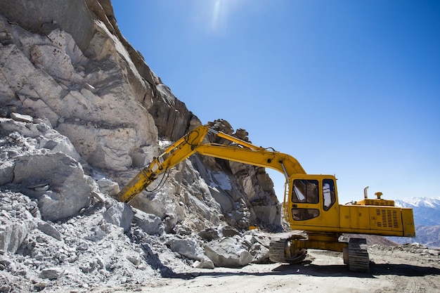 Movitore di terra sul cantiere contro il cielo