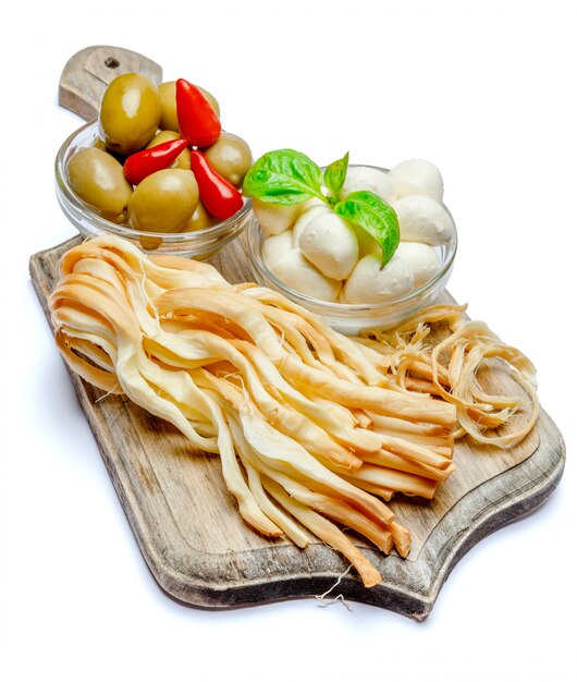 Mozzarella affumicata e italiana, olive, pepe sul tagliere di legno