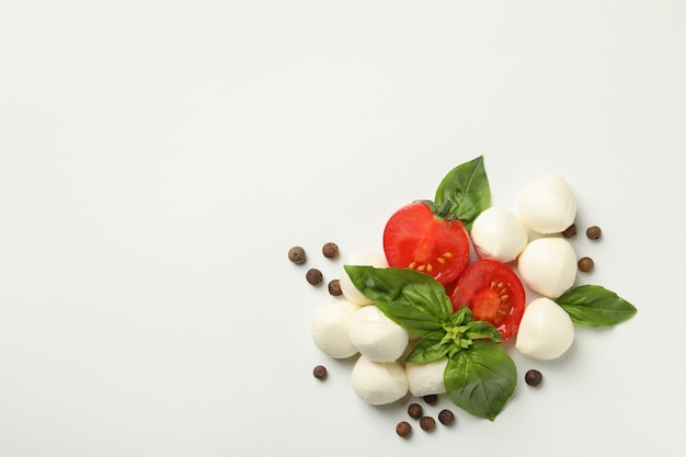 Mozzarella, basilico, pomodoro e pepe su sfondo bianco, spazio per il testo