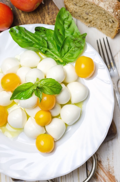 Mozzarella fresca con pomodori gialli e basilico.