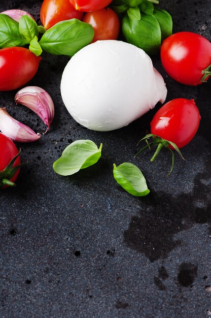 Mozzarella, pomodoro e basilico sulla tavola nera