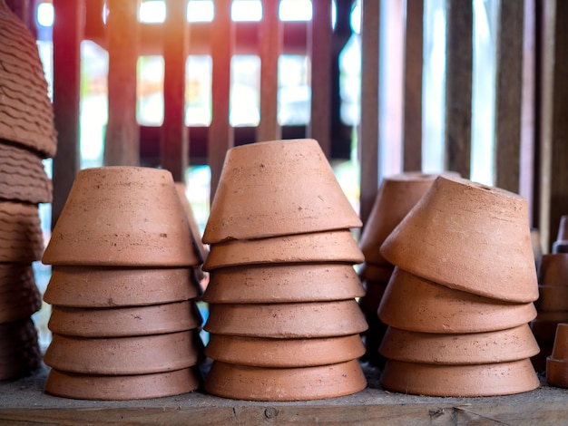 Mucchi di vasi di terracotta sul vecchio scaffale di legno