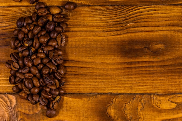 Mucchio dei chicchi di caffè sulla tavola di legno rustica. Vista dall'alto