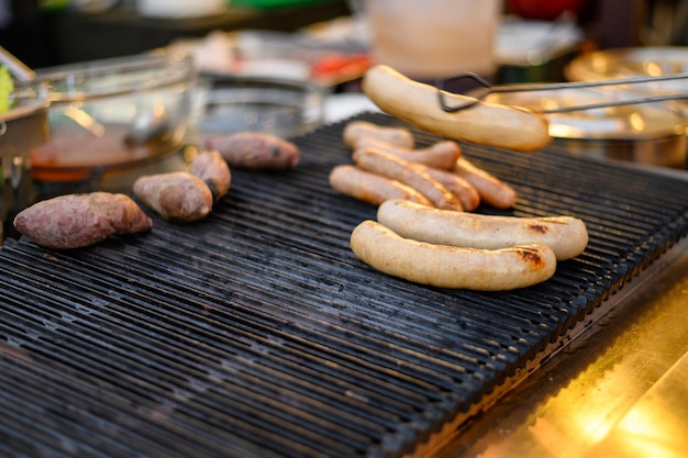 Mucchio della salsiccia di maiale bianca che griglia sulla stufa