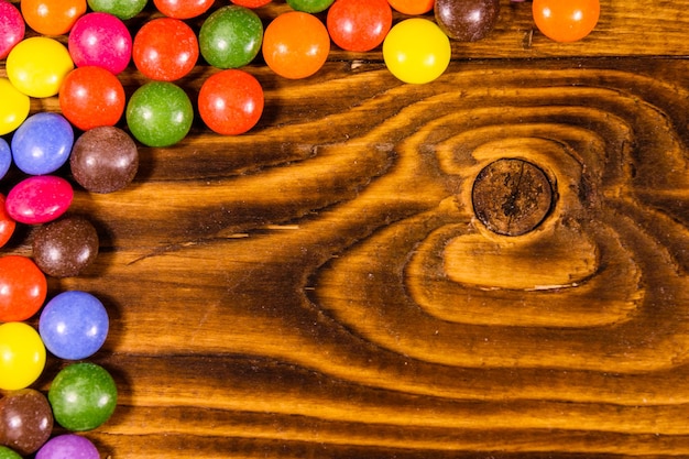 Mucchio delle caramelle multicolori su un tavolo di legno Vista dall'alto