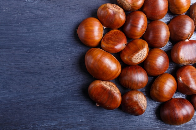 Mucchio delle castagne dolci su fondo di legno nero