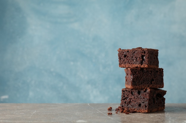 Mucchio delle fette deliziose della torta di cioccolato sulla tavola grigia, spazio per testo