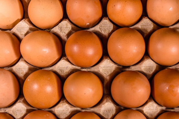 Mucchio delle uova di gallina in vassoio di carta sulla tavola di legno. Vista dall'alto