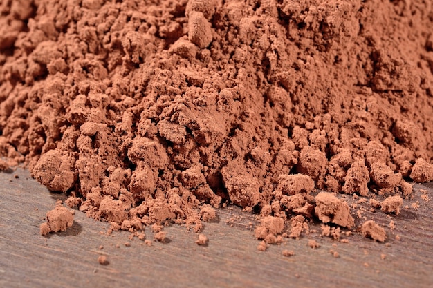 Mucchio di cacao in polvere su uno sfondo di legno