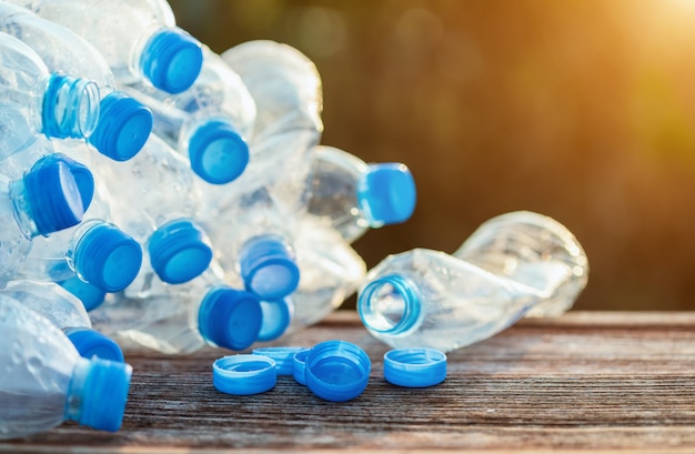 Mucchio di chiara bottiglia di acqua di plastica vuota sulla plancia di legno.