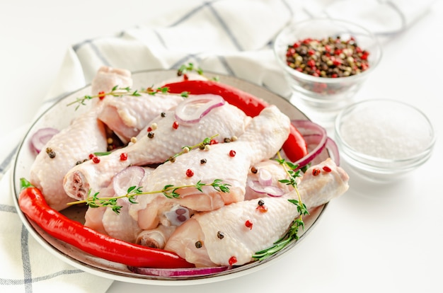 Mucchio di cosce di pollo crudo o bacchette con spezie. Avvicinamento. Cibo organico e concetto di cibo sano.