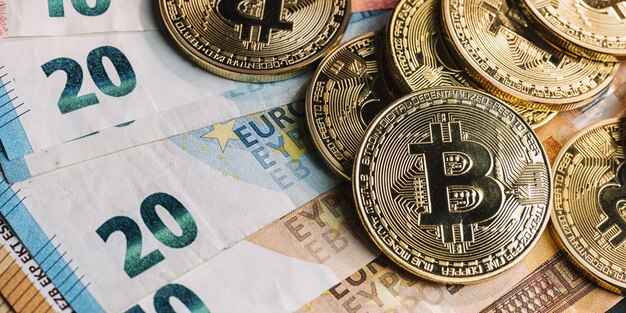 Mucchio di criptovaluta Bitcoin sopra le banconote in euro