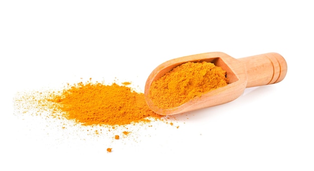 Mucchio di curcuma curcuma in polvere e paletta di legno su sfondo bianco