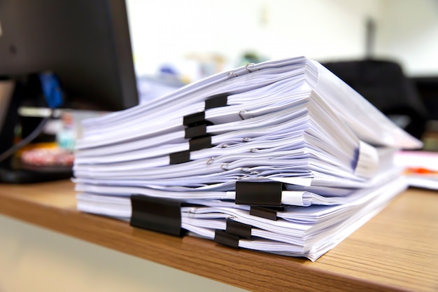 Mucchio di documenti molto documenti sulla scrivania ufficio impilare.